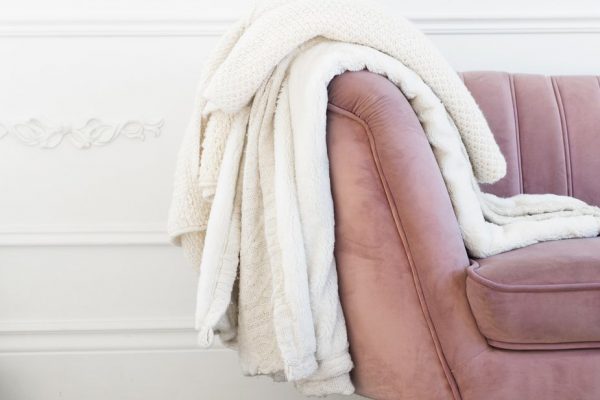 blush coloured couch with blankets