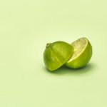 lime cut in half on green surface